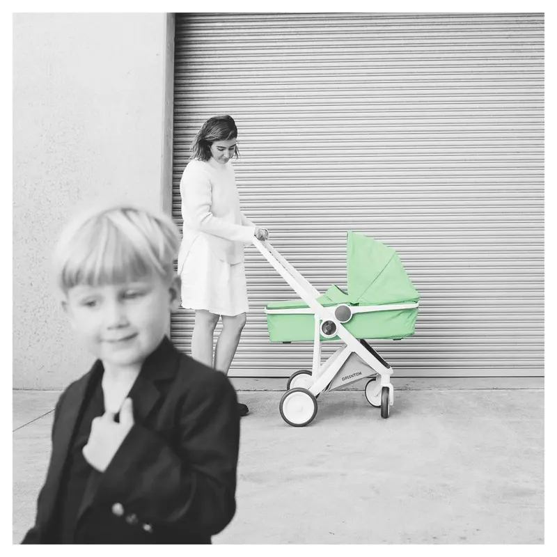 Greentom campaign photograph with a mint green stroller in colour against a black-and-white street scene