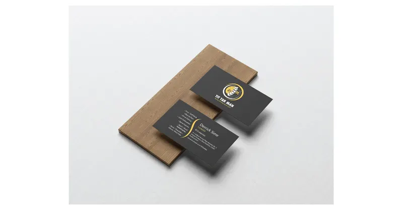 Tit Tar Man business cards in charcoal and yellow, displayed on a wooden board