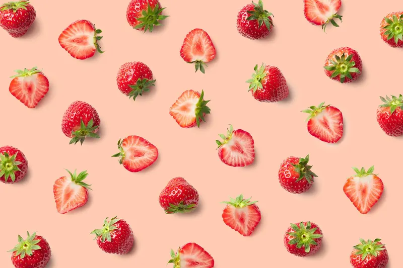 YORO strawberry pattern of whole and halved berries on a peach background